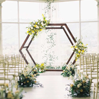 Wedding ceremony setup with floral decorations and a hexagonal arch.