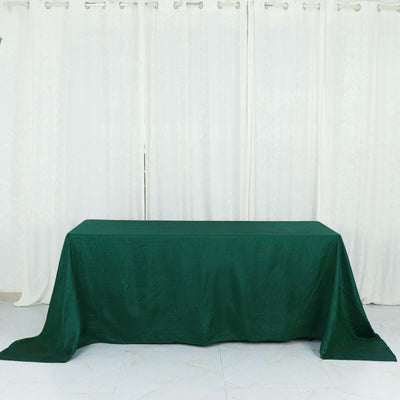 Green tablecloth draped over a table against a white backdrop.