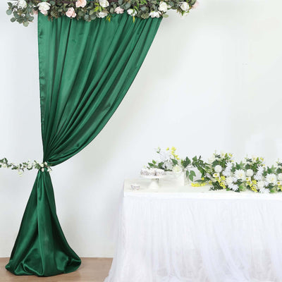 Green satin drapery with floral arrangement on a white table