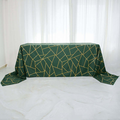 Green tablecloth with geometric gold pattern on a plain background.