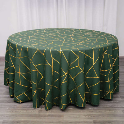 Round green tablecloth with geometric yellow patterns on a wooden surface.