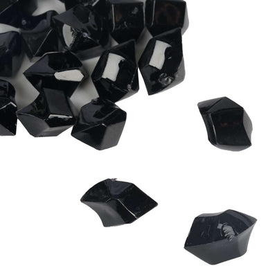 Black polished gemstones scattered on a white background