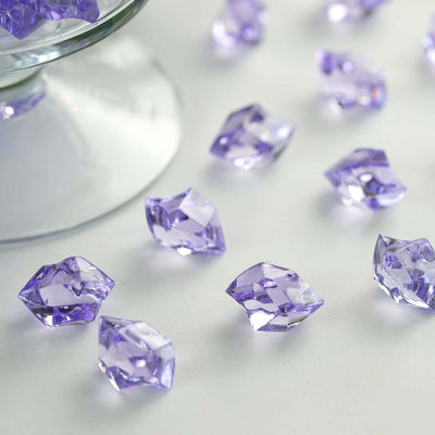 Purple decorative glass gems scattered on a surface.