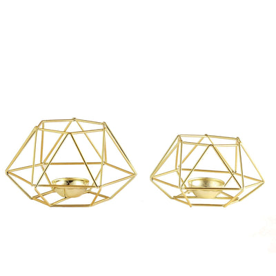 Gold geometric candle holders in two sizes on a white background