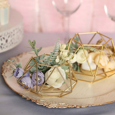 Geometric gold terrariums with flowers on a decorative plate.