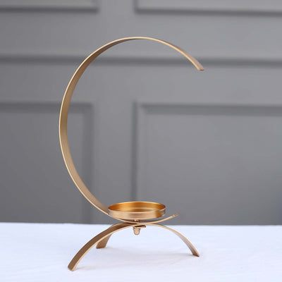 Gold crescent candle holder on a white background.