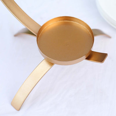 Gold metal plant stand with a circular top and three sleek legs.