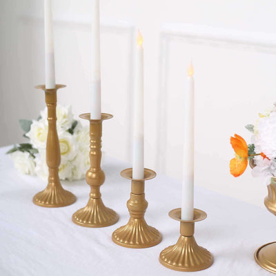Gold candle holders with white candles, elegantly arranged on a table.