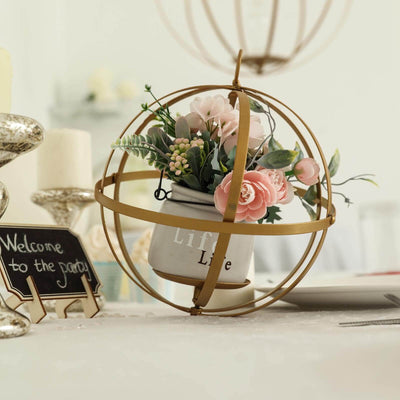 Decorative floral centerpiece in a gold wire orb with a white pot.