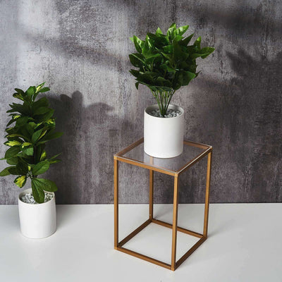 Modern gold accent table with potted plants in stylish interior setting.