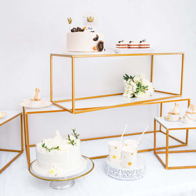 Elegant dessert display with cakes and treats on modern gold stands.