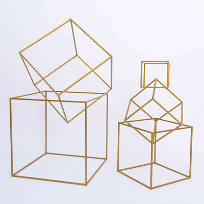 Geometric gold wire cube sculptures in various sizes on a white background