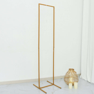 Gold metal clothing rack on a plain background