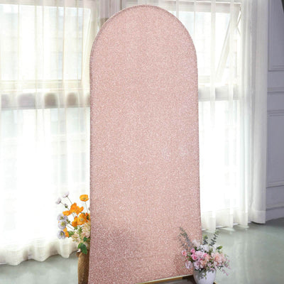Rose gold glitter backdrop with floral arrangements in a bright indoor setting.