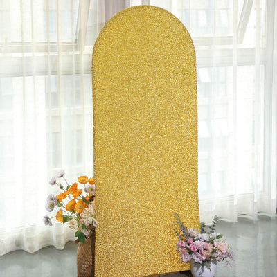 Gold glitter backdrop with floral arrangements in a bright, airy setting.