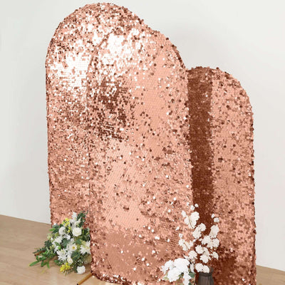 Rose gold sequin backdrop with floral arrangement on wooden table.