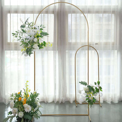 Gold floral arch display with white and yellow flowers in a bright interior setting.