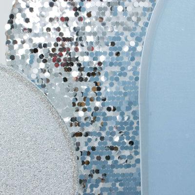 Shiny silver and blue decorative shapes on a light backdrop