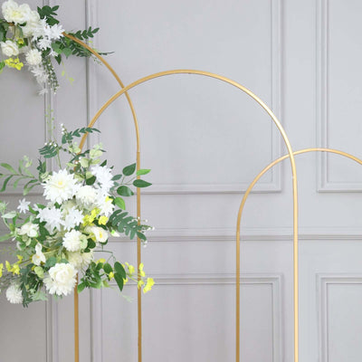 Gold arch backdrop with floral arrangements for events and photography.