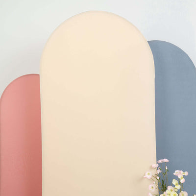Pastel arch-shaped backdrops in pink, cream, and blue with flowers in the foreground.