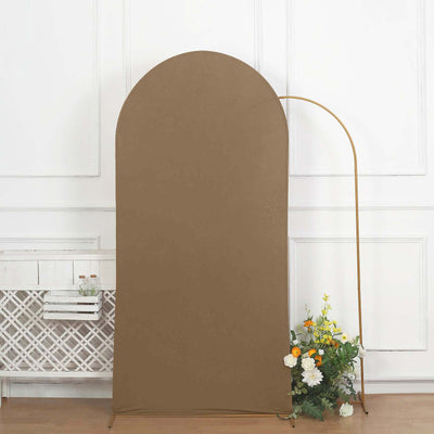 Brown fabric backdrop with a gold stand and floral arrangement.