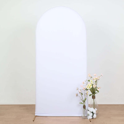White backdrop with flowers in vases beside it for staging.