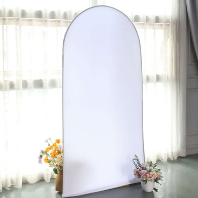 White backdrop for photography with floral arrangements in front.