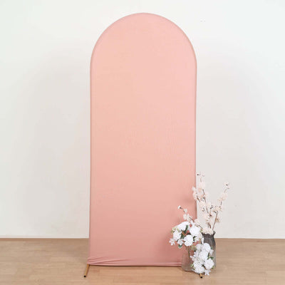 Pink arch backdrop with floral arrangement in a vase.