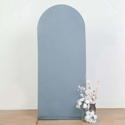 Gray fabric backdrop with arched top and floral arrangement in a vase.