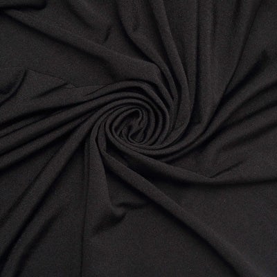 Black fabric texture in a swirling pattern.