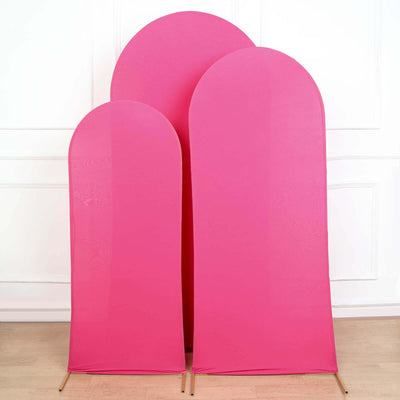 Three pink backdrop stands in varying heights on a plain background.
