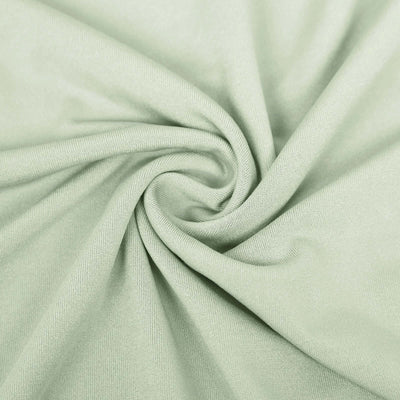 Soft green fabric texture with a smooth, swirling pattern.