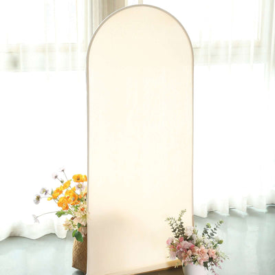 Decorative arch mirror with floral arrangement, set in a bright indoor space.
