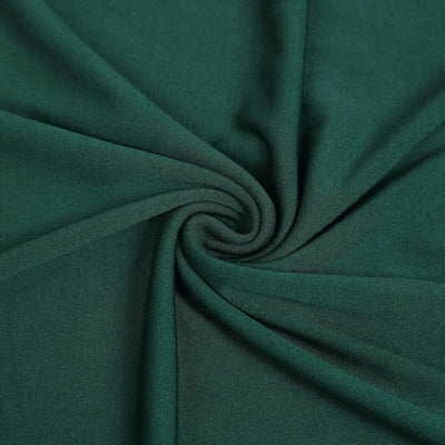 Green fabric texture in a swirling pattern.