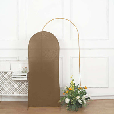 Brown backdrop stand with arch and decorative flowers in a studio setting.