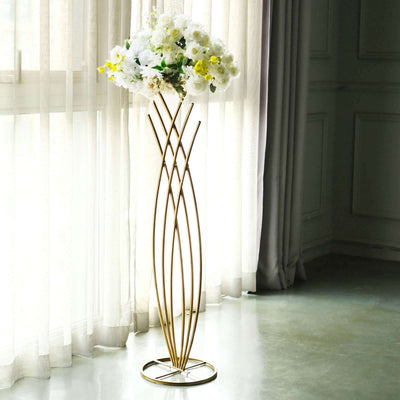 Elegant gold flower stand with white orchids, styled in a bright interior.