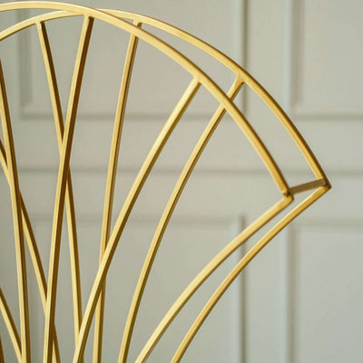 Gold fan-shaped decor accent against a neutral background.