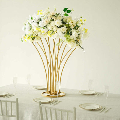 Elegant floral centerpiece with gold vase on a dining table.