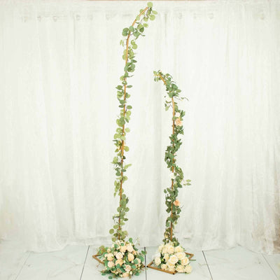 Artificial floral arrangements with greenery and roses on stands.