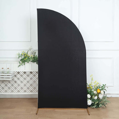 Black curved backdrop with wooden base and floral arrangement.