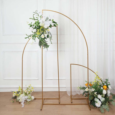 Gold floral arch with white and yellow flowers on a light wooden floor.