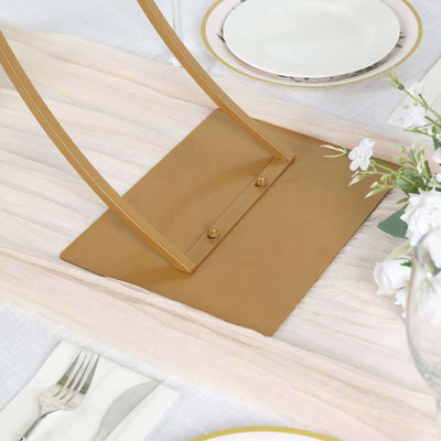 Gold table base on a textured tablecloth with elegant dining setup.