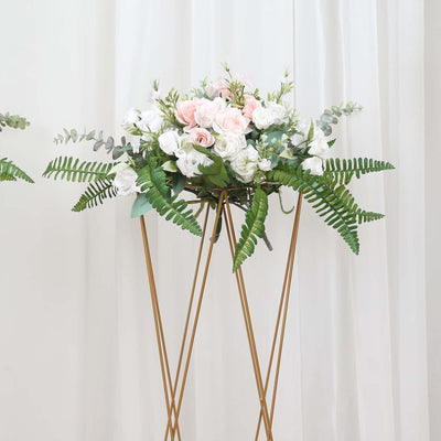 Floral arrangement with pink roses and greenery in a gold stand