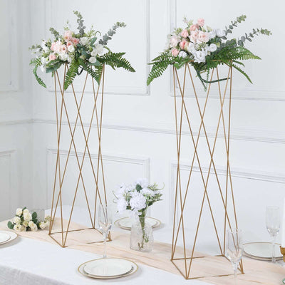 Elegant floral arrangements on gold stands for event decor.
