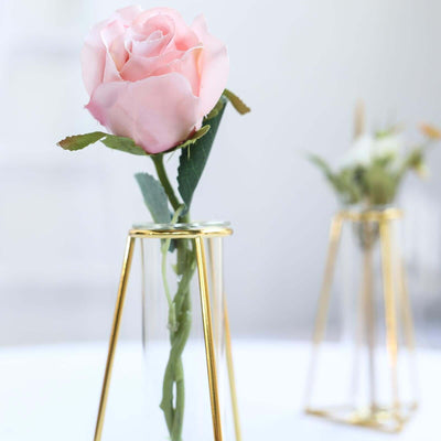 Pink rose in a gold glass vase against a soft background.