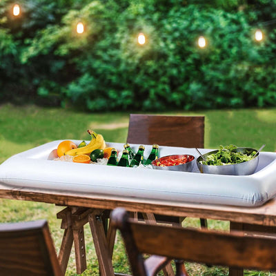 Inflatable serving tray with fruits and drinks on a garden table.