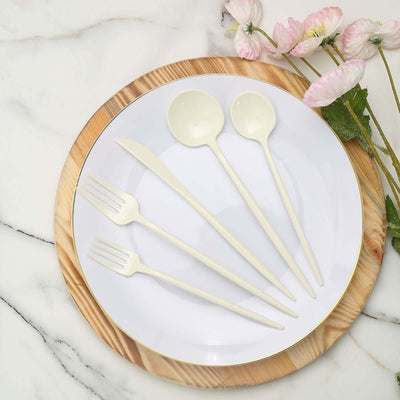Elegant cream-colored cutlery set on a white plate with a wooden charger.