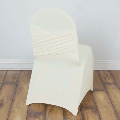 Cream chair cover with ruched back design on a wooden floor.