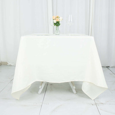 Elegant white table with floral centerpiece and glassware for dining.