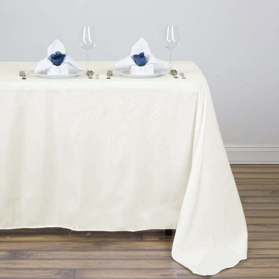 Elegant dining setup with white tablecloth, glassware, and decorative napkins.